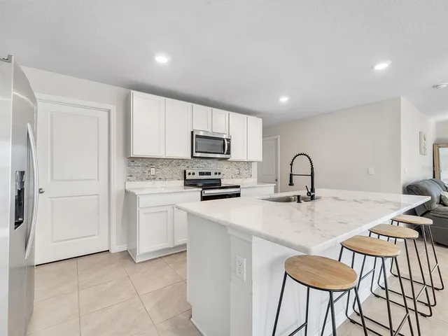 a kitchen with sink a microwave and cabinets
