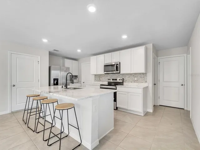 a kitchen with white cabinets and stainless steel appliances