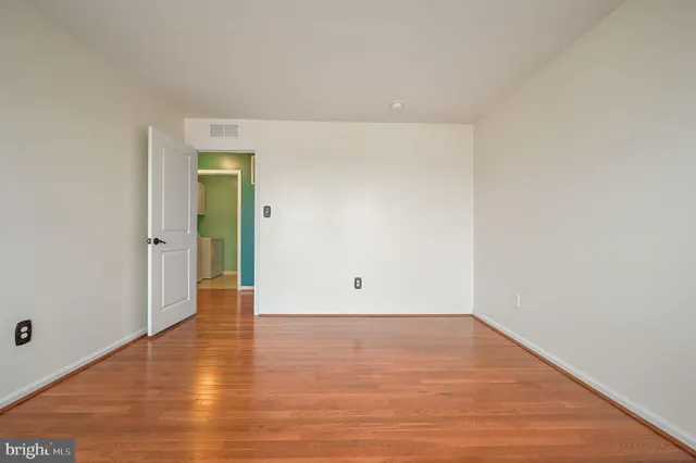 a view of an empty room with wooden floor