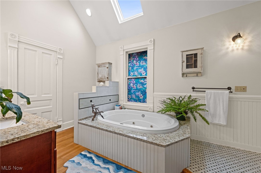 3210 Scranton Road Cleveland, OH 44109 - Photo 27 of 50 Full bath featuring a tub with jets, vanity, wainscoting, a skylight, and high vaulted ceiling