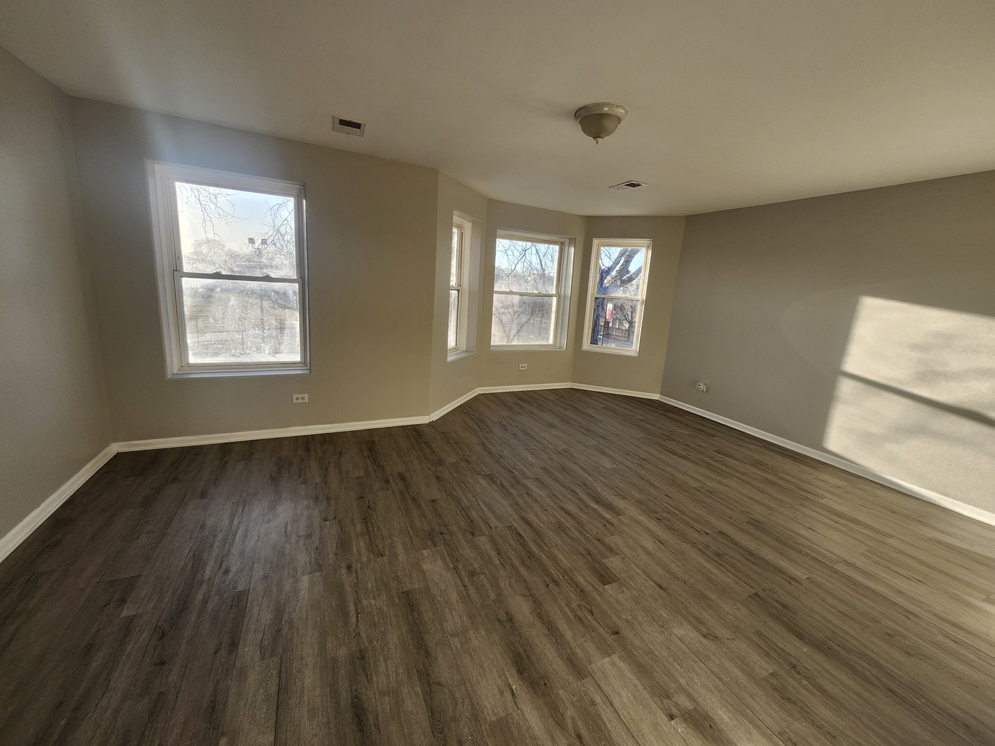 4807 South Wabash Avenue, Unit 2 Chicago, IL 60615 - Photo 2 of 7 a view of an empty room with wooden floor and a window