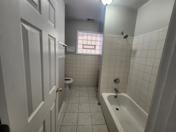 a bathroom with a tub a sink a window and a shower