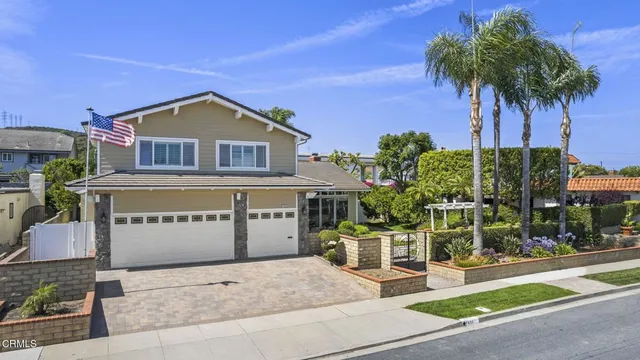 a front view of a house with a garden and plants