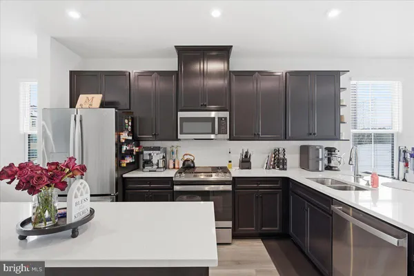 a kitchen with stainless steel appliances a sink refrigerator and cabinets