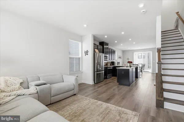 a living room with lots of furniture and kitchen view