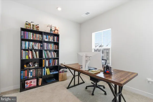 a view of a workspace with furniture and a bookshelf
