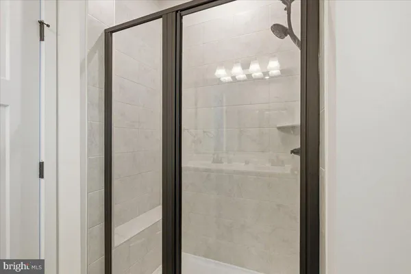 a bathroom with a glass shower door and a window