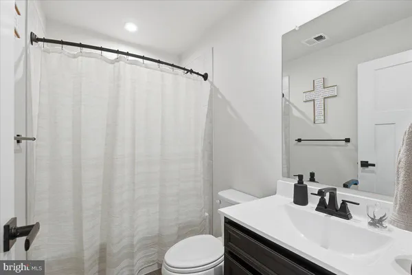 a bathroom with a sink a toilet and shower curtain