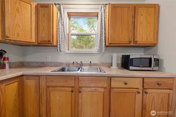 a kitchen with granite countertop a stove a sink and a microwave