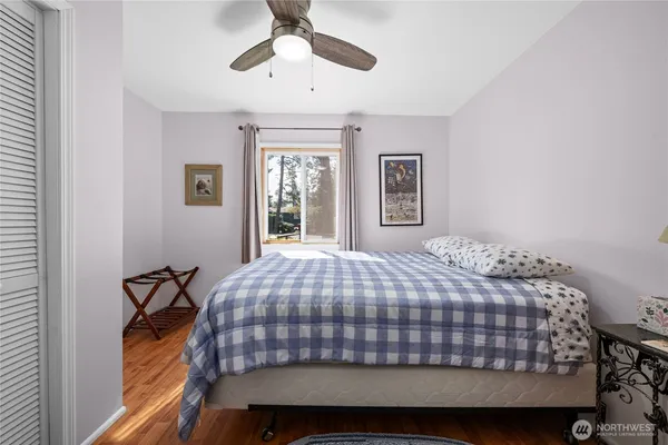 a bedroom with a bed and a painting on the wall
