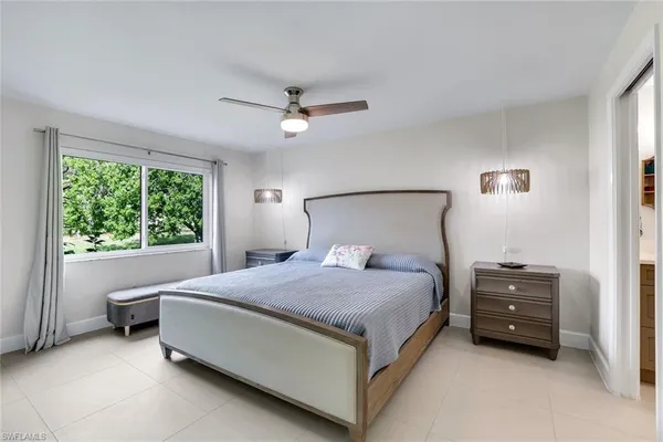 a spacious bedroom with a bed and a large window