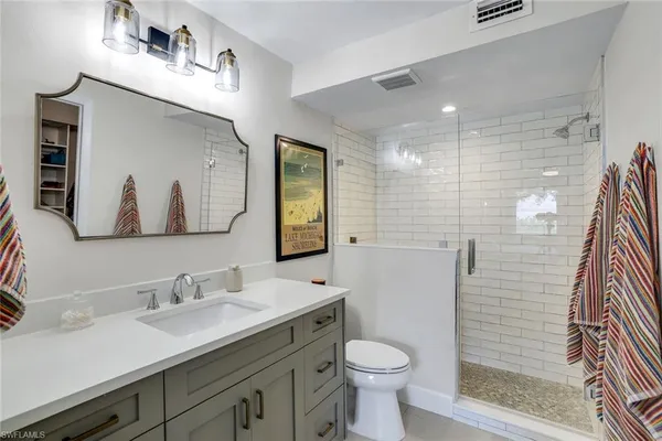 a bathroom with a sink toilet a mirror and shower