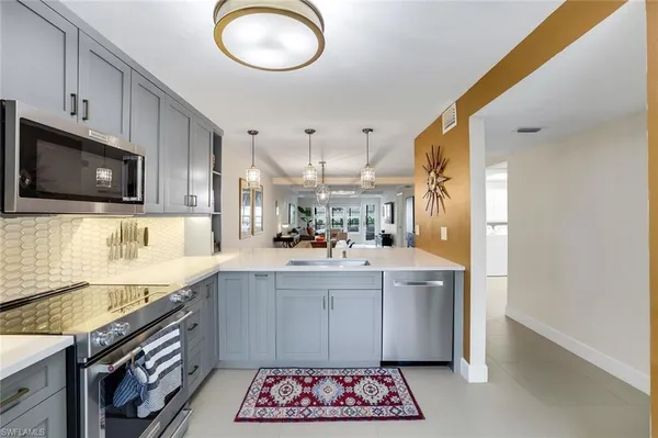 a kitchen with stainless steel appliances granite countertop a sink and a microwave