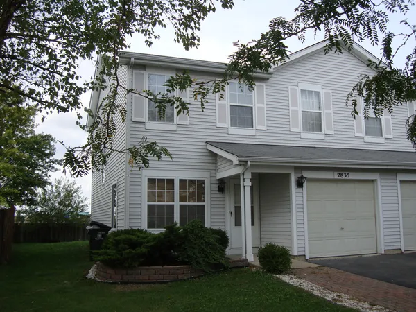 a front view of a house with a garden and plants