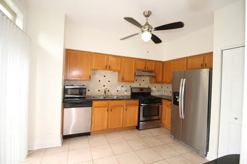 a kitchen with stainless steel appliances a stove top oven and a refrigerator