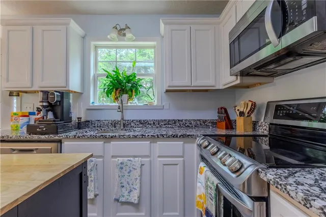 a kitchen with stainless steel appliances granite countertop a refrigerator stove and sink