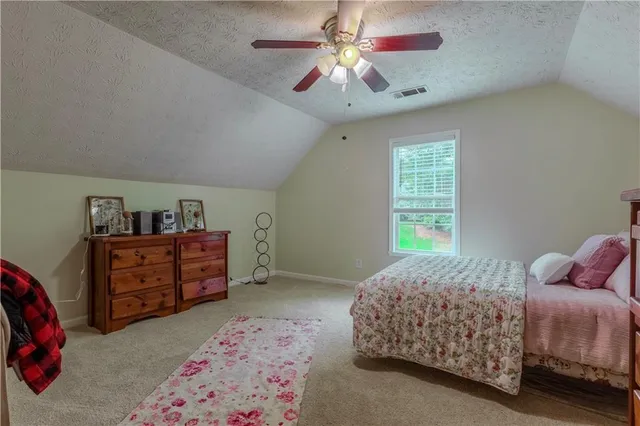 a bedroom with a bed dresser and window