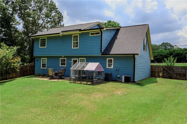 a view of a house with a yard and sitting area