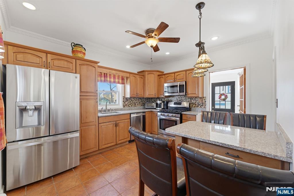 385 Berkeley Avenue Bloomfield, NJ 07003 - Photo 10 of 39 a kitchen with stainless steel appliances granite countertop a refrigerator a sink a stove and white cabinets