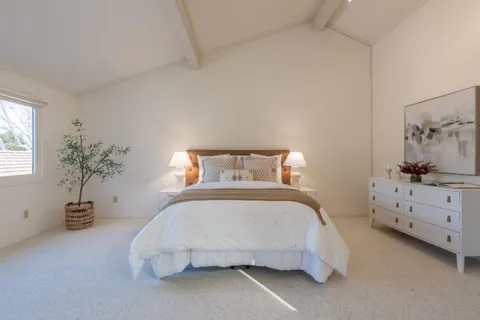 a bedroom with a bed and a potted plant