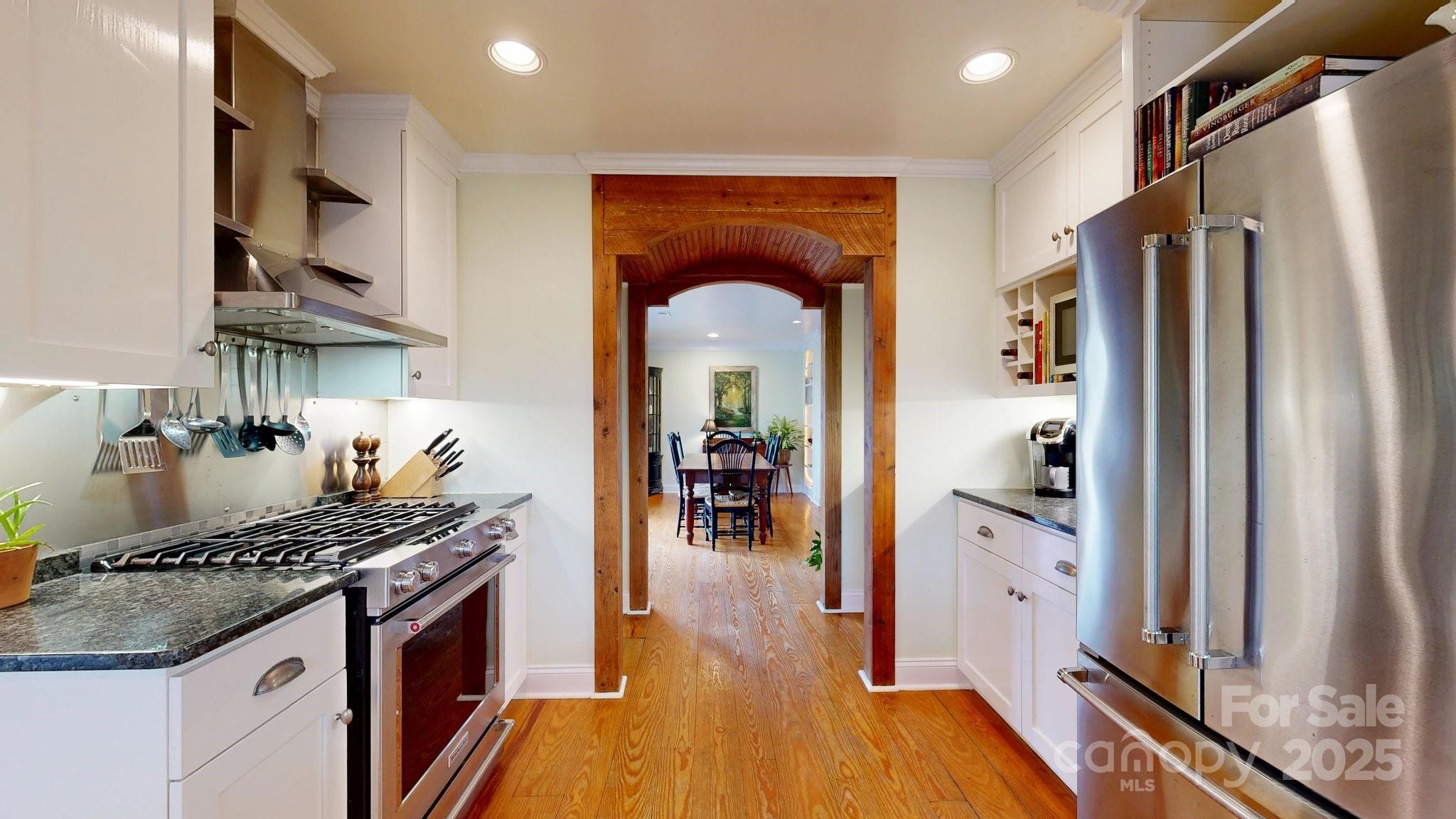 13031 Westmoreland Farm Road Davidson, NC 28036 - Photo 20 of 45 a kitchen with granite countertop a refrigerator stove and wooden floor