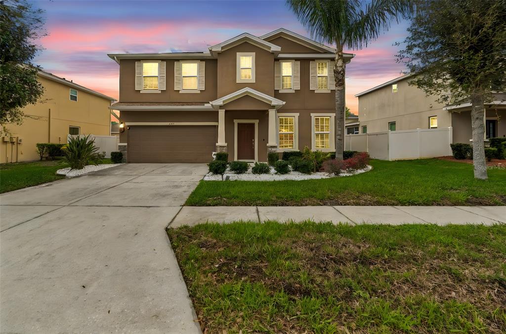 a front view of a house with a yard and garage
