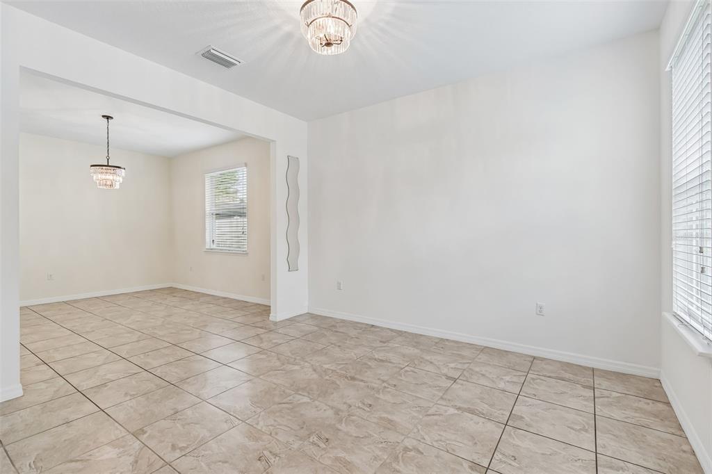 6105 Merrifield Drive Zephyrhills, FL 33541 - Photo 11 of 85 an empty room with windows and chandelier fan