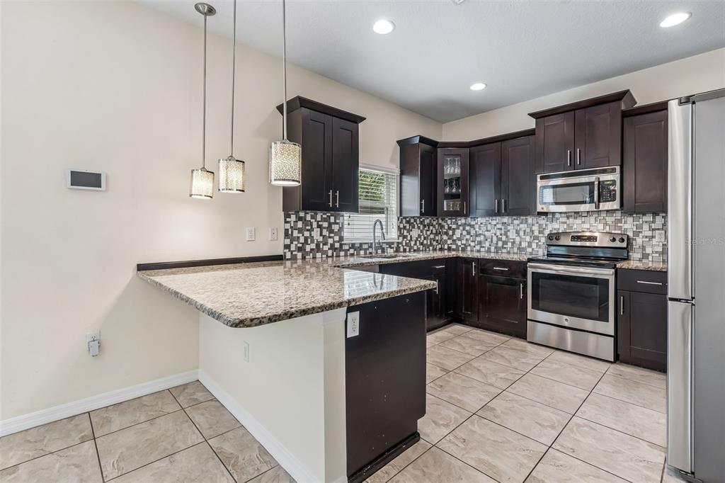 6105 Merrifield Drive Zephyrhills, FL 33541 - Photo 19 of 85 a kitchen with stainless steel appliances granite countertop a sink counter space cabinets and stainless steel appliances