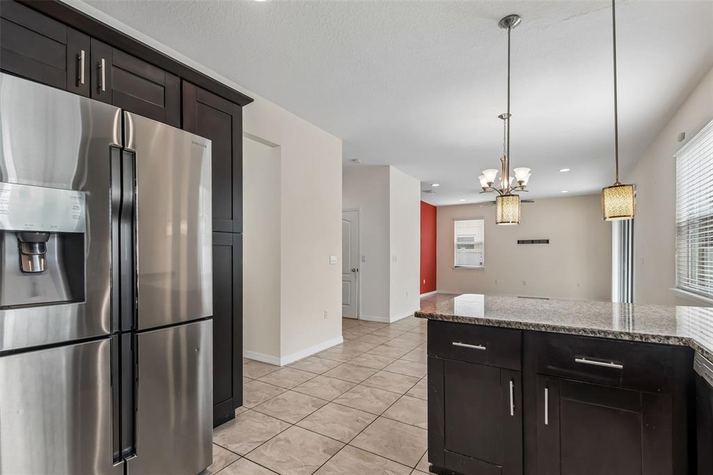 6105 Merrifield Drive Zephyrhills, FL 33541 - Photo 23 of 85 a kitchen with stainless steel appliances a refrigerator and a sink