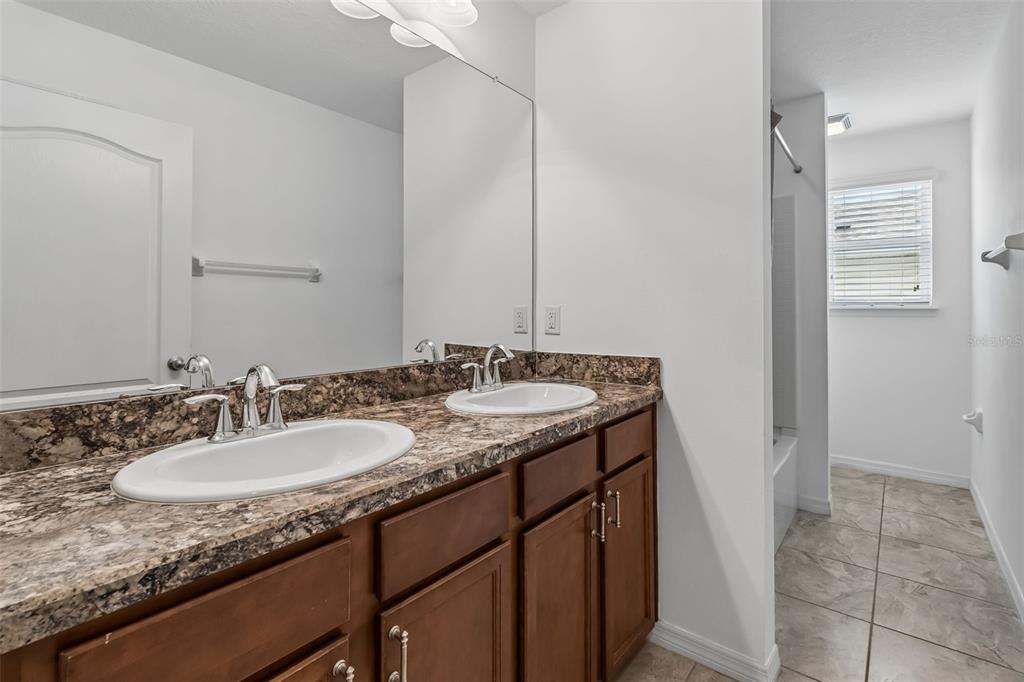 6105 Merrifield Drive Zephyrhills, FL 33541 - Photo 38 of 85 a bathroom with a granite countertop sink and a mirror