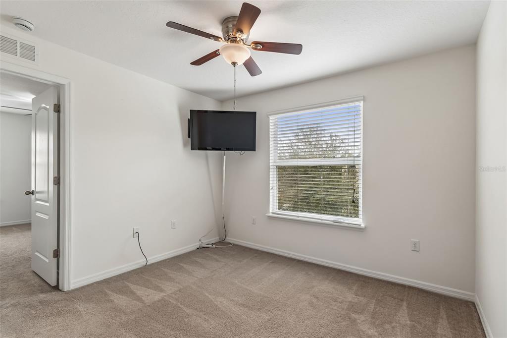 6105 Merrifield Drive Zephyrhills, FL 33541 - Photo 46 of 85 an empty room with windows and a ceiling fan