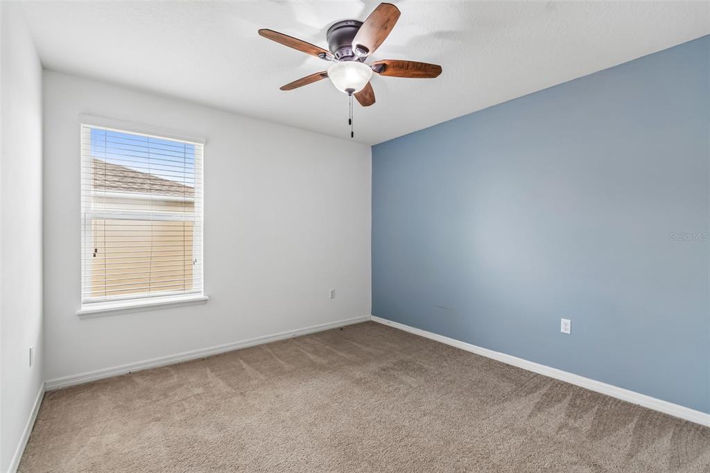6105 Merrifield Drive Zephyrhills, FL 33541 - Photo 50 of 85 an empty room with a chandelier fan and windows