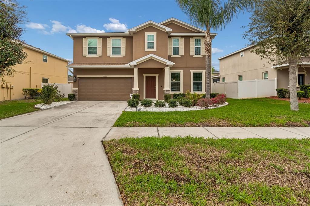 6105 Merrifield Drive Zephyrhills, FL 33541 - Photo 5 of 85 a front view of a house with a yard and garage