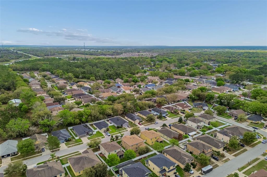 6105 Merrifield Drive Zephyrhills, FL 33541 - Photo 79 of 85 an aerial view of residential houses with outdoor space and trees