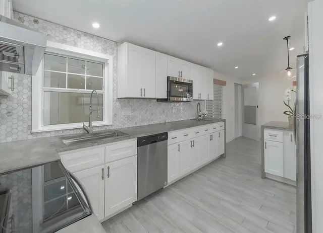 a kitchen with stainless steel appliances granite countertop a sink and cabinets