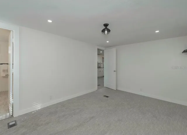 an empty room with a ceiling fan and carpet