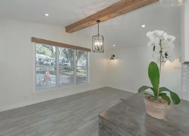 a view of a room with wooden floor and a window