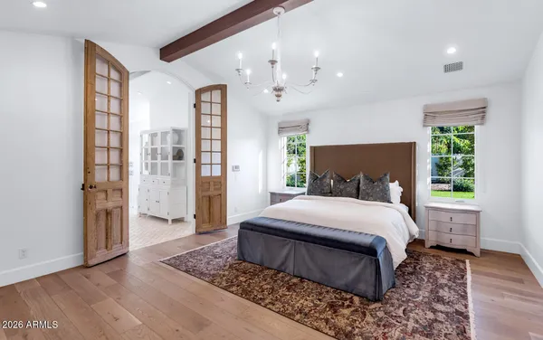 a bedroom with a large bed a rug and a window