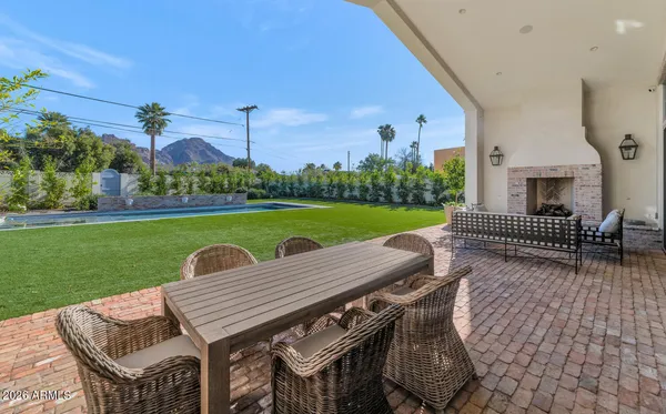 a view of a patio with table and chairs with wooden floor and fence