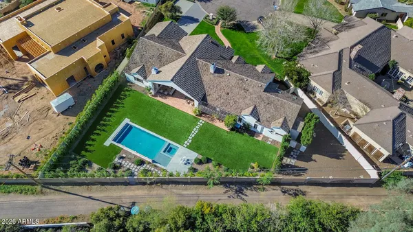 an aerial view of a house with a yard and lake