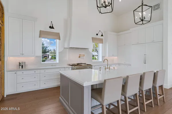 a kitchen with a dining table chairs cabinets and stainless steel appliances