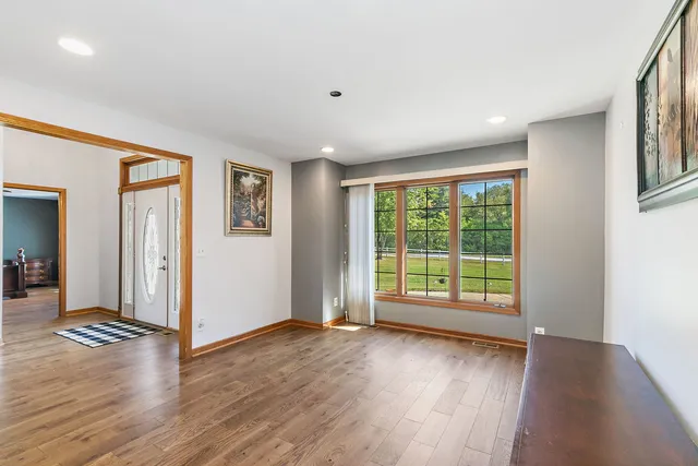 a view of an empty room with glass door and wooden floor