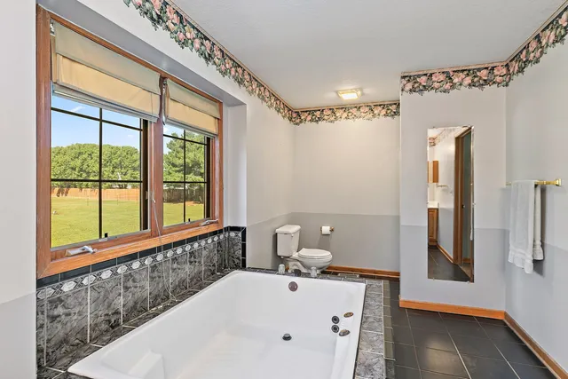 a bathroom with a bathtub and a window