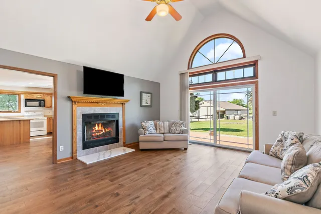 a living room with furniture a fireplace and a flat screen tv