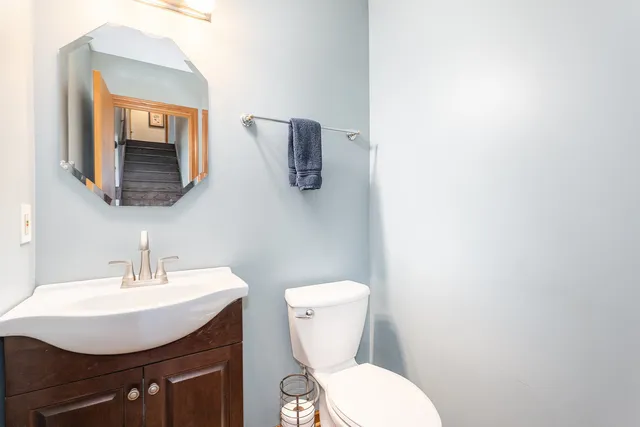 a bathroom with a toilet a sink and mirror
