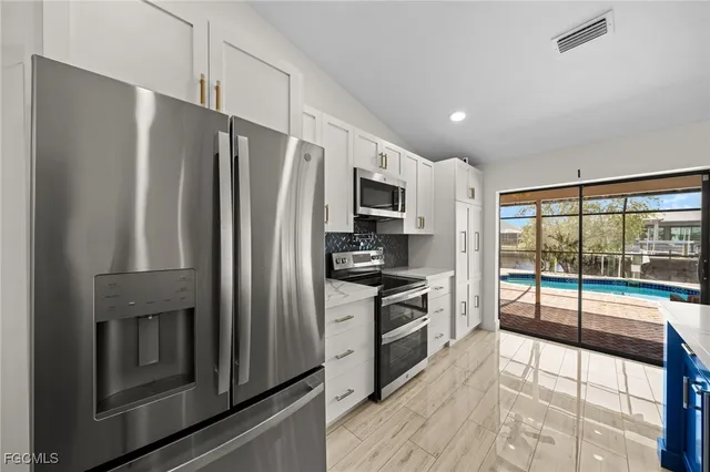 a kitchen with stainless steel appliances a refrigerator sink and stove