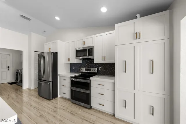 a kitchen with stainless steel appliances a refrigerator stove and microwave