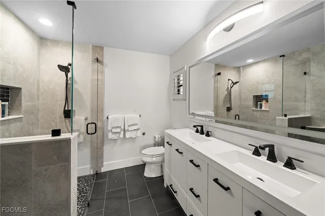 a bathroom with a double vanity sink mirror and toilet