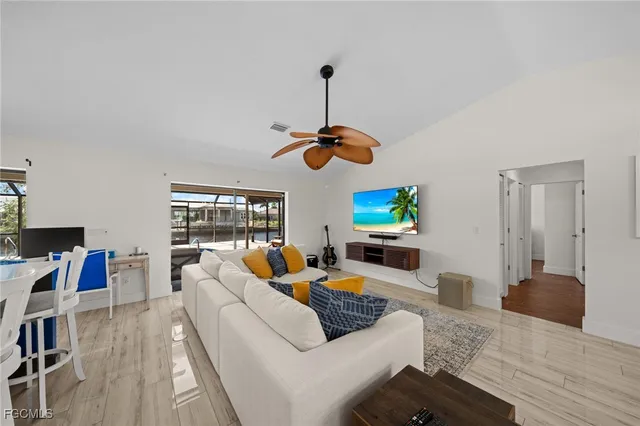 a living room with furniture a chandelier and a floor to ceiling window