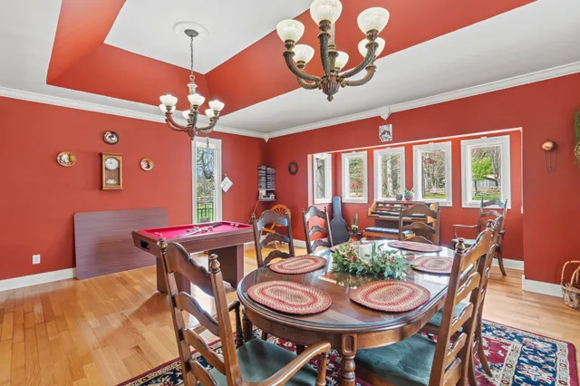 a living room with a table chairs and a chandelier
